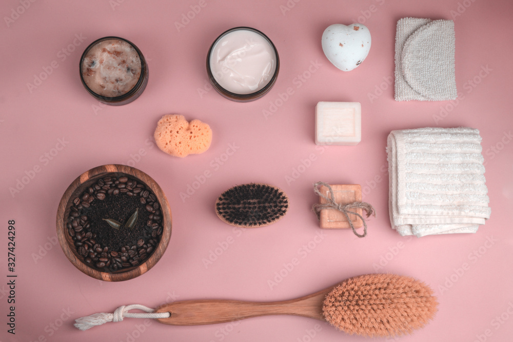 Spa set as Scrub, lotion, soaps, cotton towel, peel glove on pink background Spa set as Scrub, lotion, soaps, cotton towel, peel glove on pink background