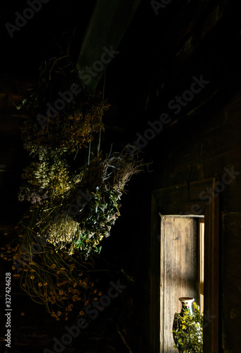 House of the village healer. Drying healing herbs and light in an old window photo