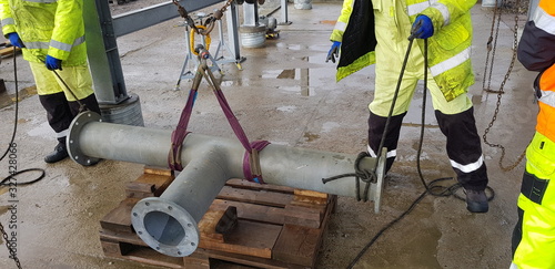 Tableau sur toile riggers move the pipe using two chain blocks