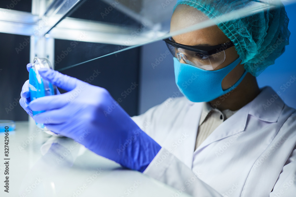 Side view portrait of female scientist holding petri dish while working on bio research in laboratory, copy space Side view portrait of female scientist holding petri dish while working on bio research in laboratory, copy space