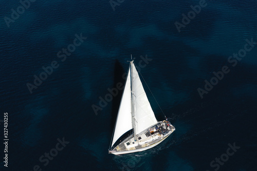 Aerial drone photo of beautiful sail boat cruising in deep blue open ocean sea