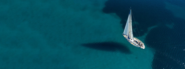 Aerial drone ultra wide photo of beautiful sail boat sailing in tropical exotic bay with emerald clear sea