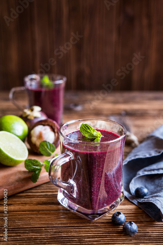 Blueberry and mangosteen fruit smoothie in a glass jar photo