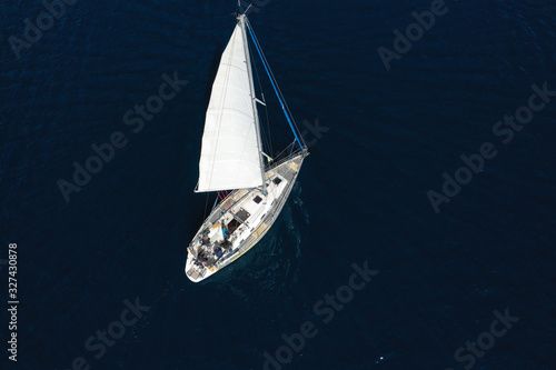 Aerial drone photo of beautiful sail boat cruising in deep blue open ocean sea © aerial-drone