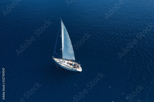 Aerial drone photo of beautiful sail boat cruising in deep blue open ocean sea