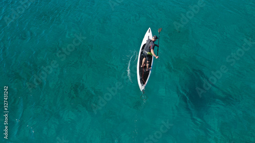 Aerial drone photo of fit man practising Stand Up Paddle or SUP in tropical exotic bay with emerald sea © aerial-drone