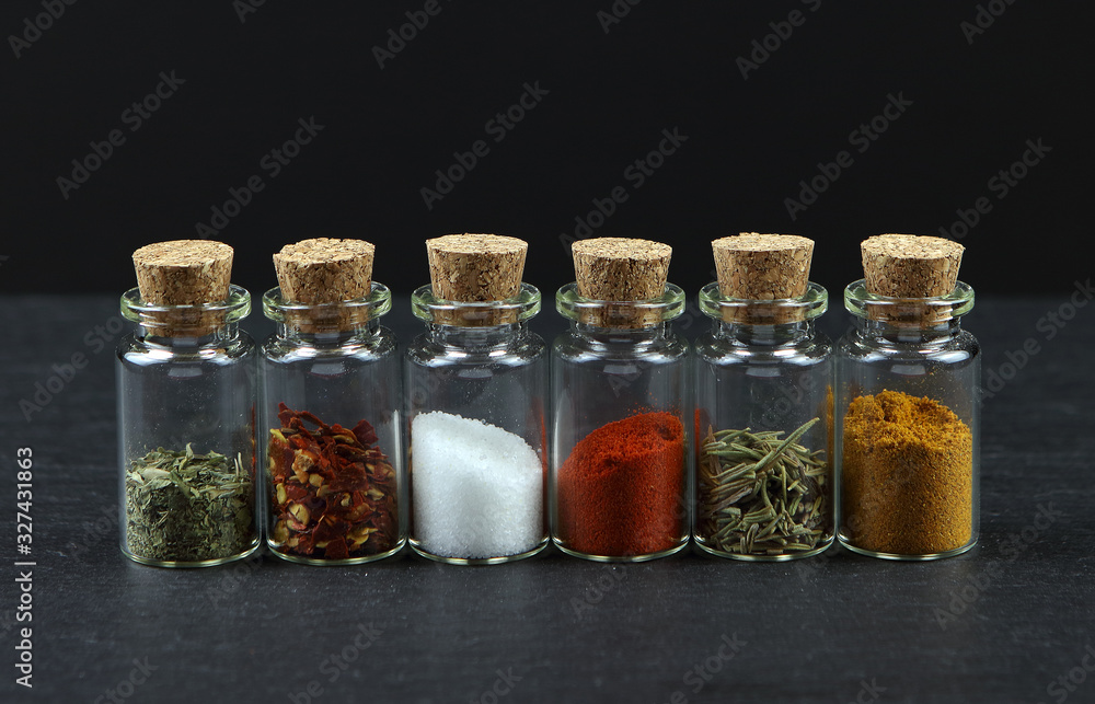 Photo of a line of glass vials with cork bungs filled with different spices Photo of a line of glass vials with cork bungs filled with different spices