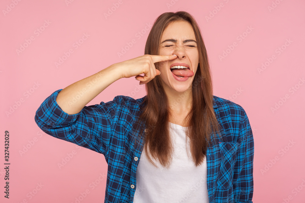 Portrait of girl in checkered shirt picking nose pulling out boogers with disgust expression, bad manners concept and misconduct, uncultured gross habit. indoor studio shot isolated on pink background Portrait of girl in checkered shirt picking nose pulling out boogers with disgust expression, bad manners concept and misconduct, uncultured gross habit. indoor studio shot isolated on pink background