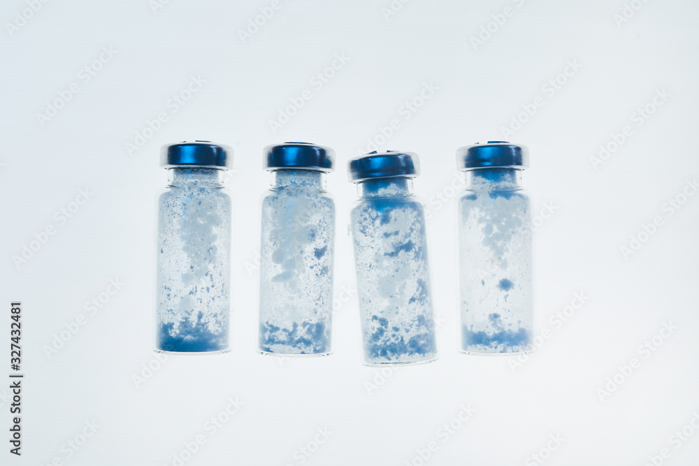 Top view background image of glass vials in row on white table in medical laboratory, copy space Top view background image of glass vials in row on white table in medical laboratory, copy space