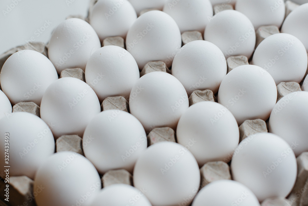 Tray of white fresh eggs close-up on a cardboard form. Agricultural industry