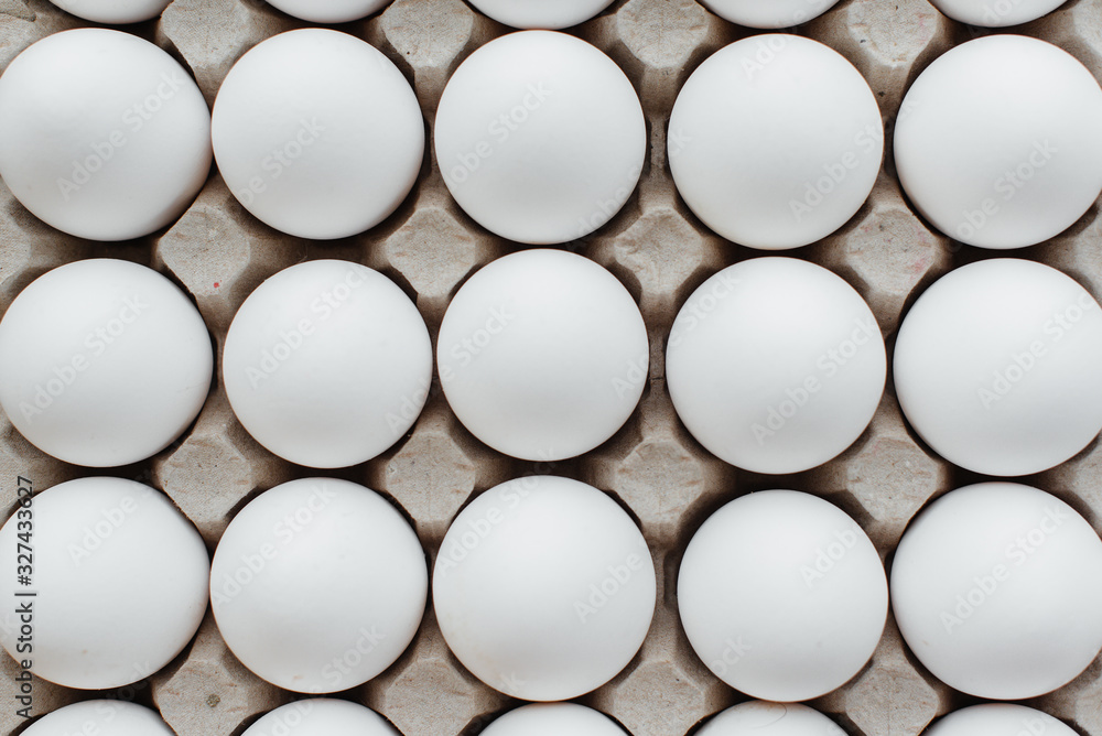 Tray of white fresh eggs close-up on a cardboard form. Agricultural industry Tray of white fresh eggs close-up on a cardboard form. Agricultural industry