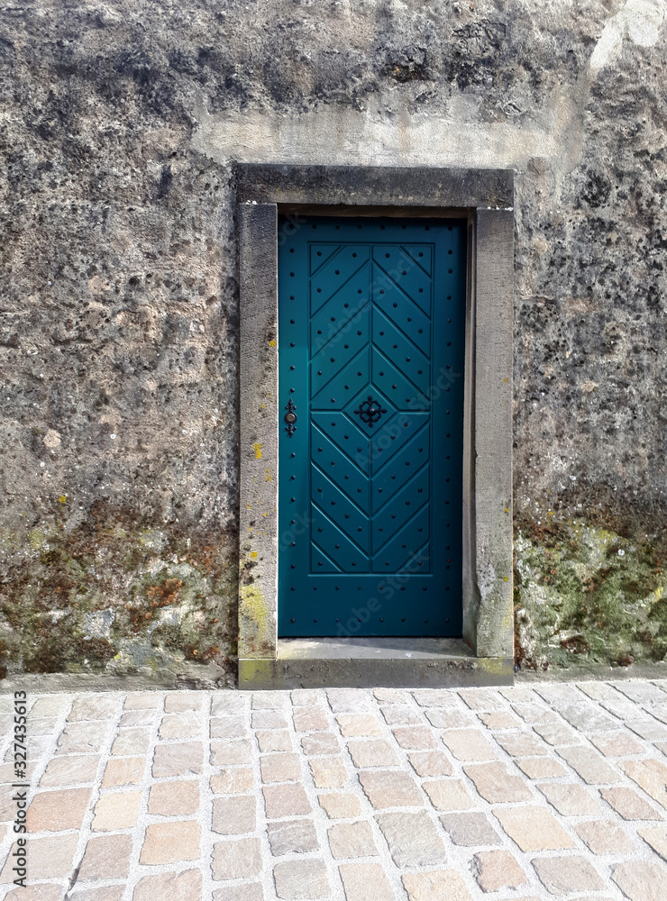 old blue wooden door in stone wall old blue wooden door in stone wall