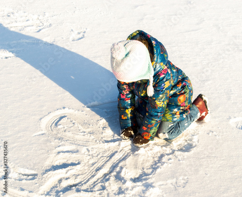 child plays in the snow
