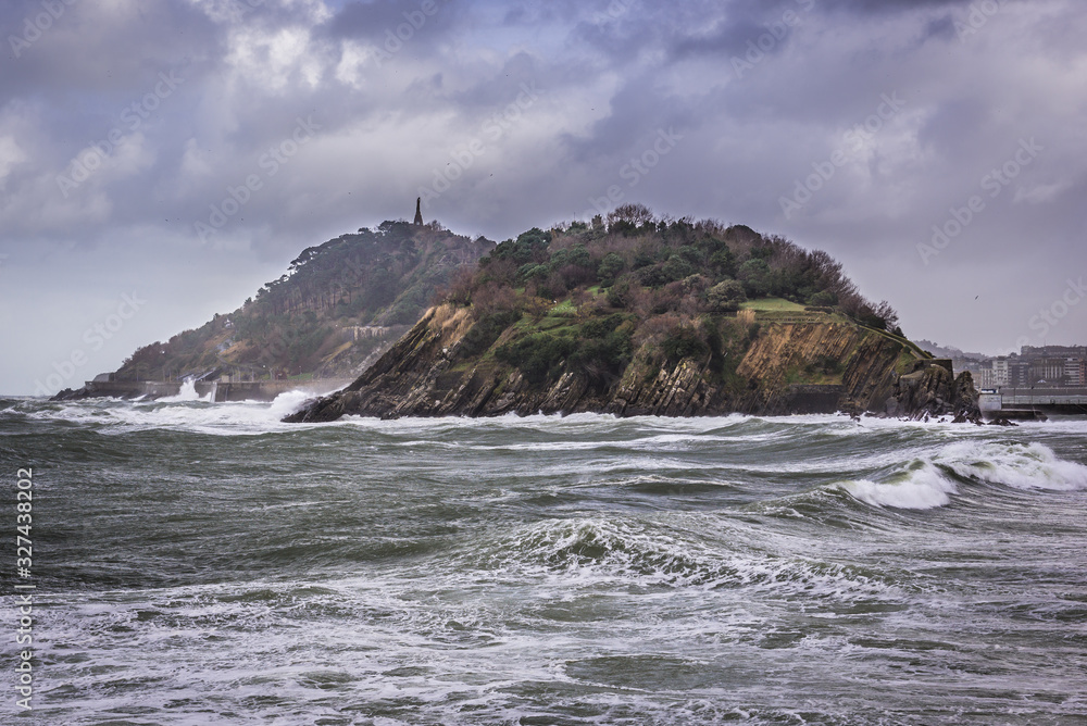Obraz premium View on the La Concha Bay with isle of Santa Clara and Urgull mountain in San Sebastian city in Spain