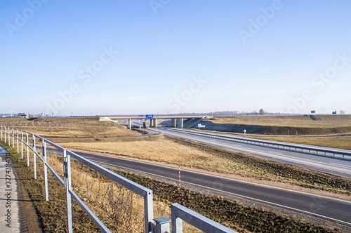 Empty asphalt highway in spring with bridge
