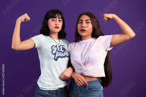 Two young empowered Mexican ladies bending their arm