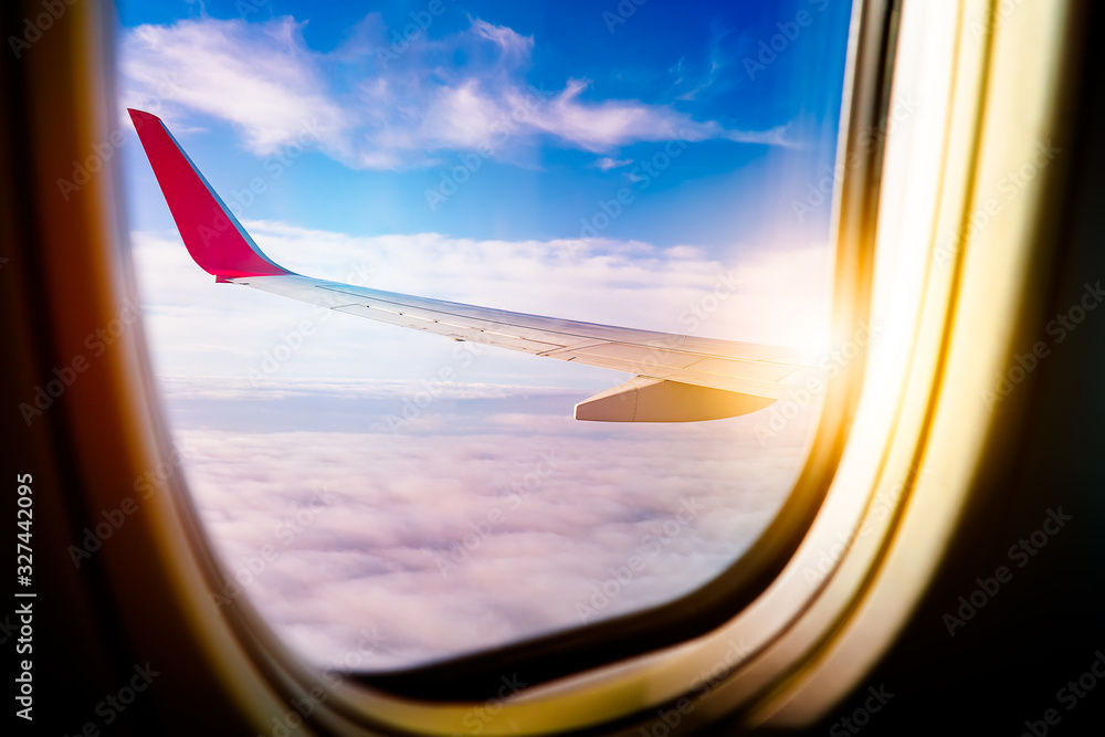Black background with copy space with look of seat window frame of airplane flight see view of sunset clouds, airplane wing, ice mountains for luxury trip tourism travel transportation concept