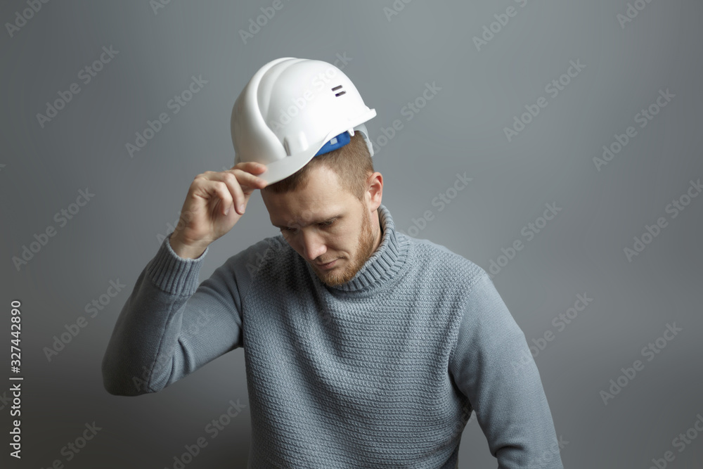 Man worker takes off the white construction helmet Man worker takes off the white construction helmet