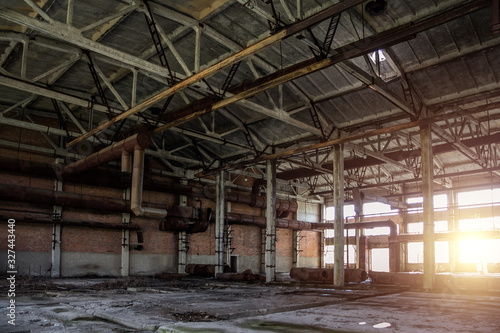 Old abandoned industrial building with rusty remnants of pipeline