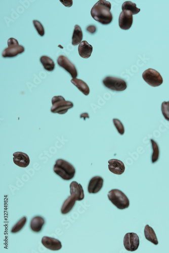 Falling coffee grains on a light blue background  freezing in motion