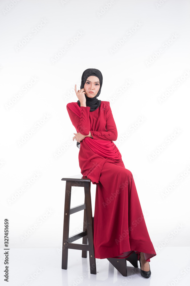 Beautiful female Asian model in various poses wearing a red Malaysian traditional wear isolated on white background. Beauty and fashion concept. Full length portrait