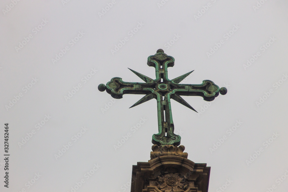 An iron cross at the top of a church in Rio de Janeiro under a gray sky