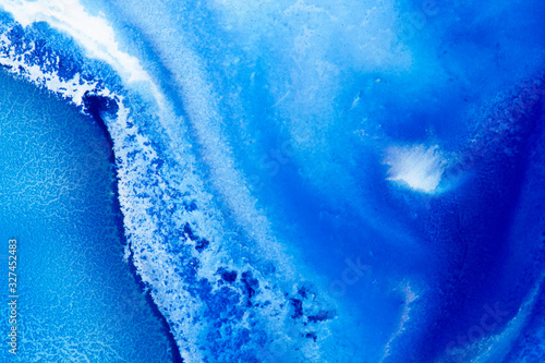 Classical blue and white watercolor paint in abstract spreading forms similar to satellite imagery with arctic snow hills and seas with glaciers melting in macro. Stains of paint in macro for design. © Anton