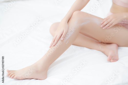 Beautiful asian woman touch skin leg smooth with cream and lotion for hydration and smooth, girl applying body care and cosmetic for silky and soft, beauty perfect with wellness, health and care.