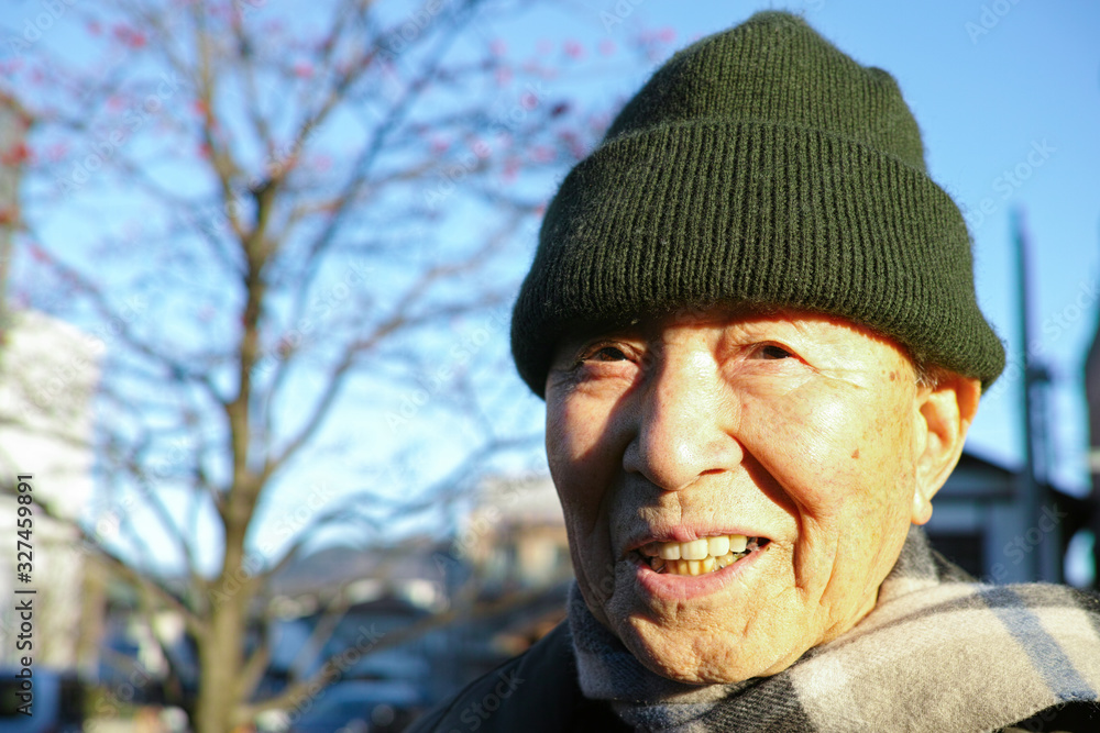 An old Asian man wearing a wooly hat in the Winter An old Asian man wearing a wooly hat in the Winter