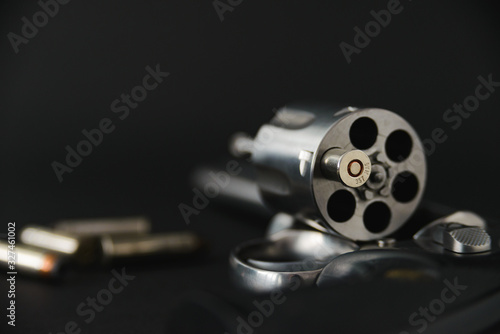 Konstfotografi 357 magnum caliber revolver pistol, cylinder open with a single bullet protrudin