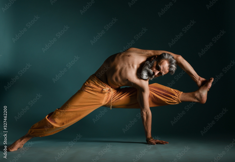 Old man with grey beard doing yoga, pilates, fitness training