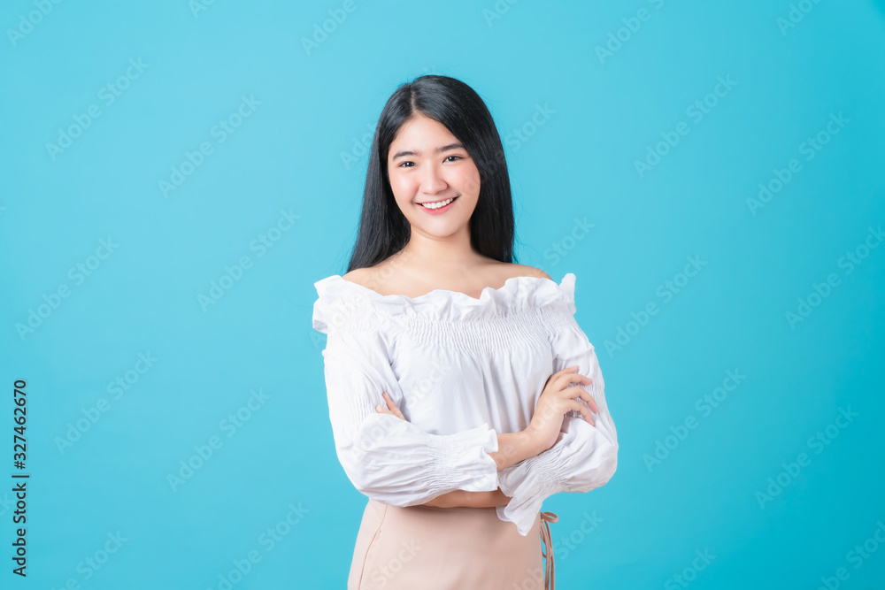 Cheerful beautiful Asian woman stand and crossed arms on blue background. Cheerful beautiful Asian woman stand and crossed arms on blue background.