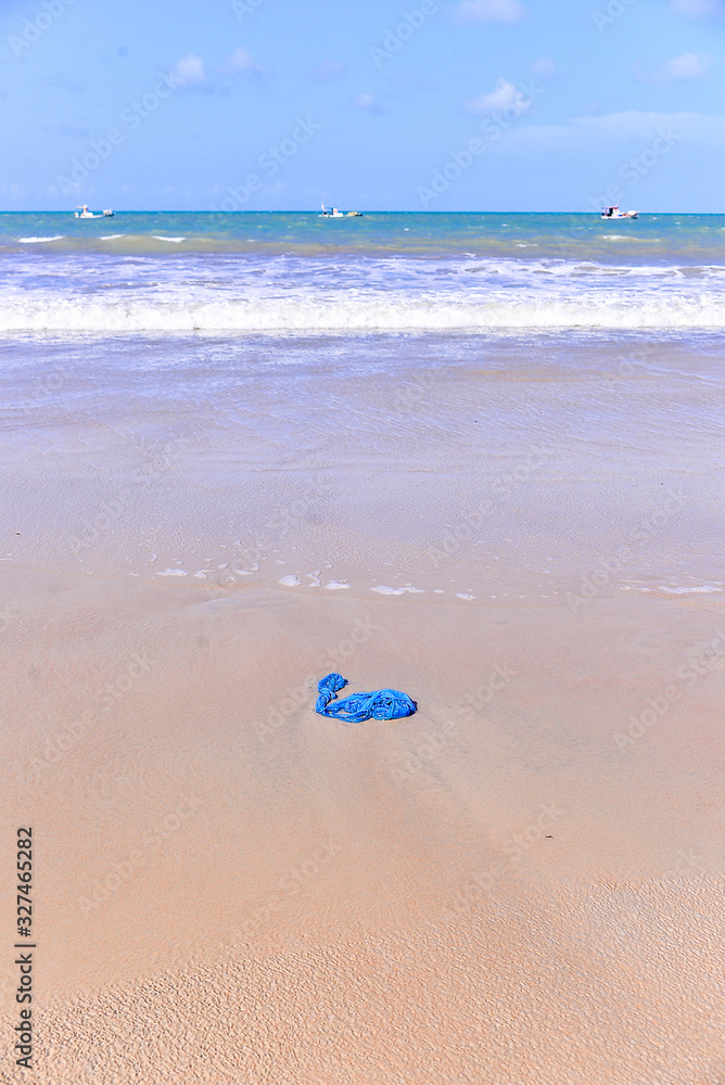 blue trash bag thrown on the beach, plastic bag thrown into the sea, World environment day