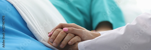 Close-up view of private psychotherapist consoling client. Doctor holding patients hands in day hospital. Nurse comfort and support sick person. Medicine concept