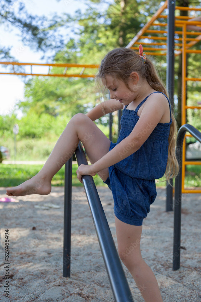 Young girl in a blue dress on a playground