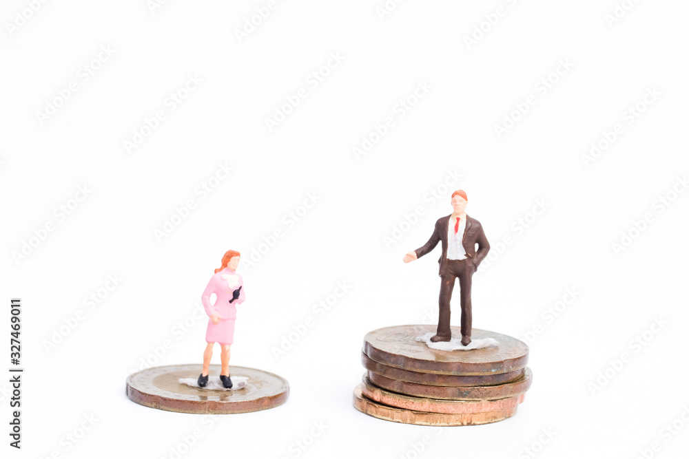 Fototapeta Miniature with stacks of coin for salary equality for men and women.