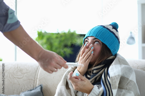 Close-up of sick woman having treatment at home. Sad female covering face with hand. Catching cold season. Seasonal sickness and self-treatment concept
