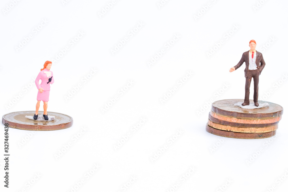 Fototapeta Gender pay gap concept with miniature and coins on white background. World request equal payment between women and men salary in same profession.