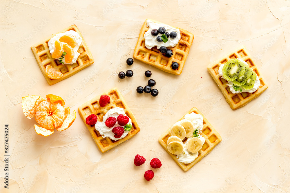 Belgian waffles with creamy cheese and berries on beige background top-down Belgian waffles with creamy cheese and berries on beige background top-down