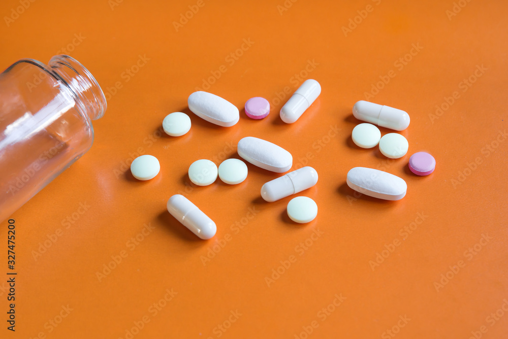 pills of various forms on orange background pills of various forms on orange background