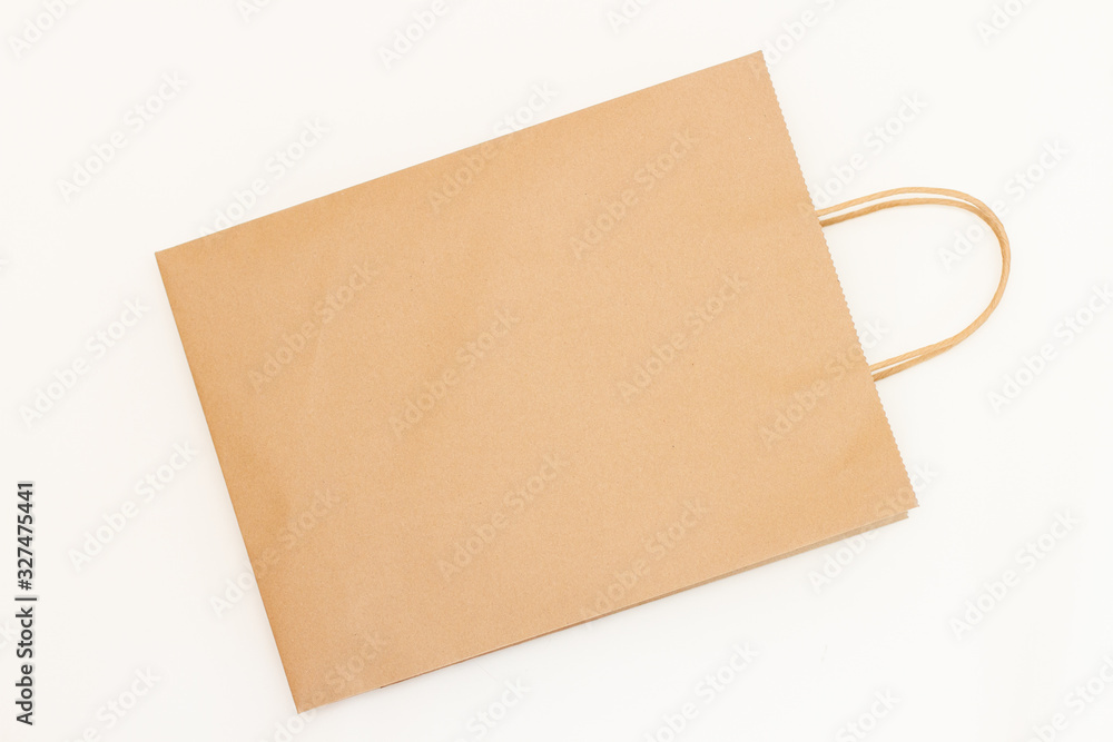 Top view brown paper shopping bag on white background. Empty craft paper bag