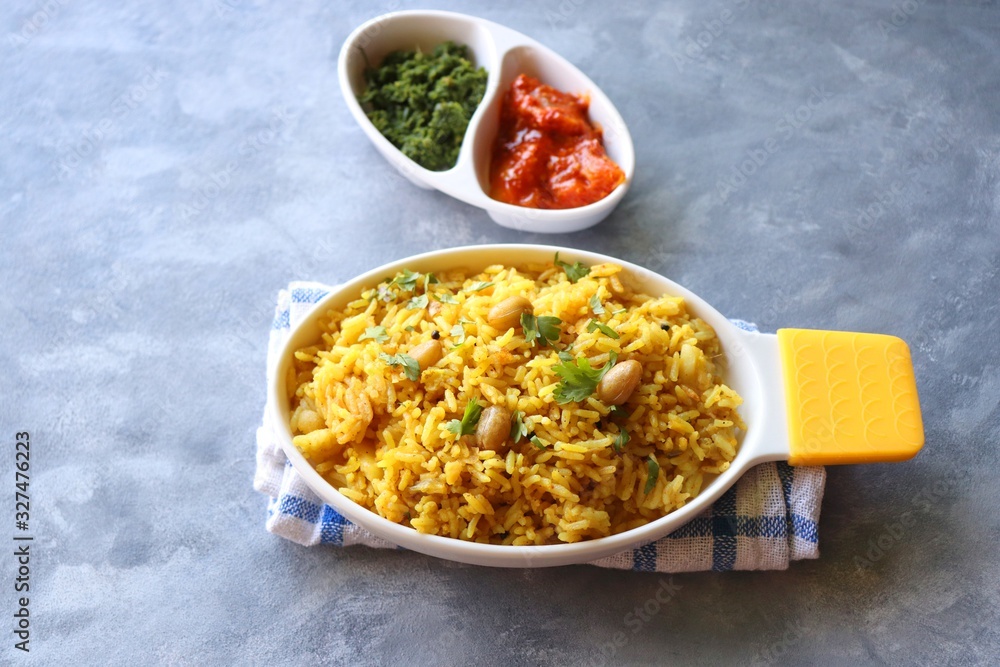 Indian comfort Food - Fresh Masala peanuts rice also known as Peanuts Pulav or rice khichdi. Garnished with coriander. Served hot with green chutney and mango pickle. with Copy space. Indian comfort Food - Fresh Masala peanuts rice also known as Peanuts Pulav or rice khichdi. Garnished with coriander. Served hot with green chutney and mango pickle. with Copy space.