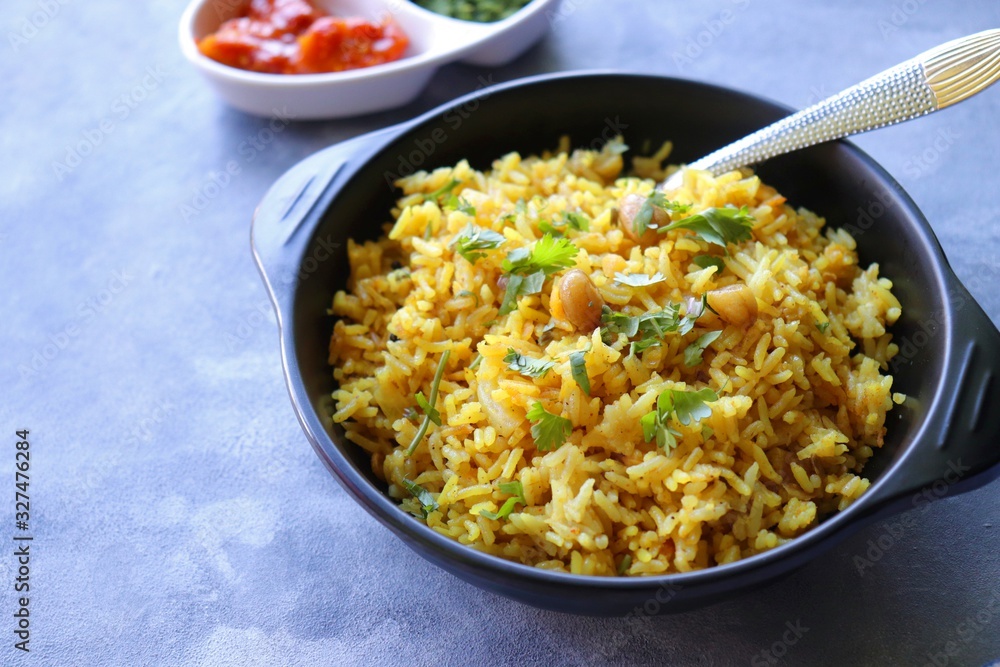 Indian comfort Food - Fresh Masala peanuts rice also known as Peanuts Pulav or rice khichdi. Garnished with coriander. Served hot with green chutney and mango pickle. with Copy space. Indian comfort Food - Fresh Masala peanuts rice also known as Peanuts Pulav or rice khichdi. Garnished with coriander. Served hot with green chutney and mango pickle. with Copy space.