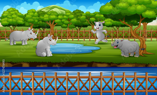 Scene with many rhinos playing in the zoo open cage