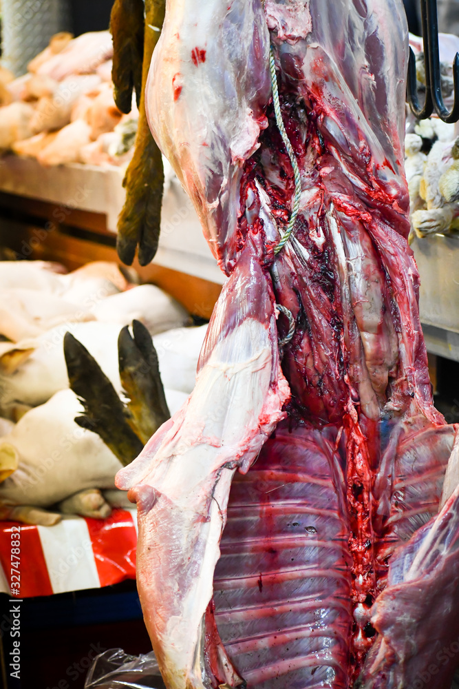 Deer hanging with ribs exposed in a public market in Mexico City.