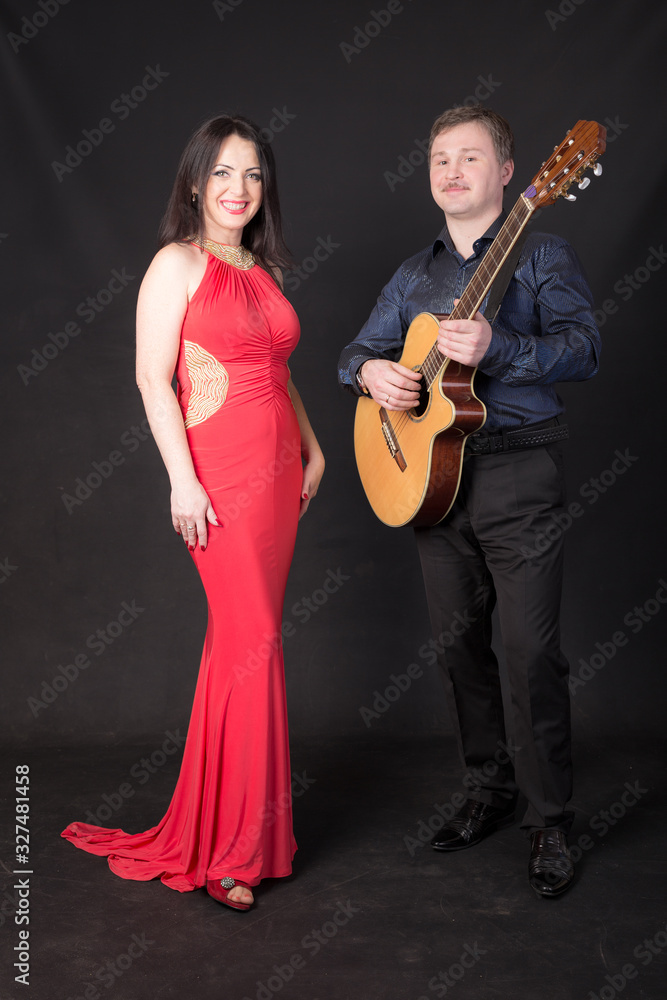 woman in a red dress and a guitarist woman in a red dress and a guitarist
