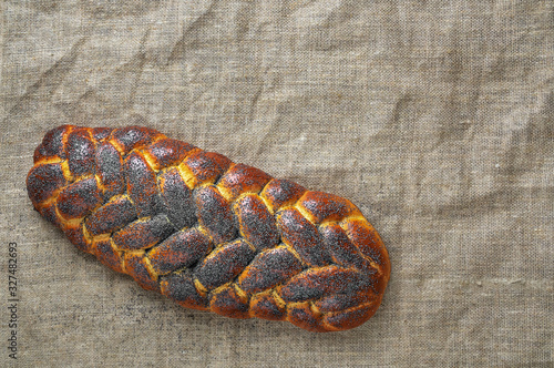 freshly baked sweet braided bread ( challah bread) on a cloth, dark wooden background, top view, copy space photo