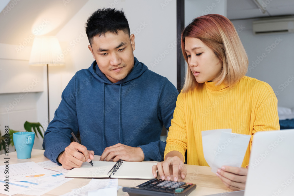 Asian couple list home financial bill budget on table in kitchen at new house.family expense Asian couple list home financial bill budget on table in kitchen at new house.family expense