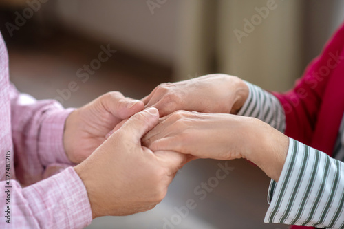 Close up picture of mans hands holding womans hands