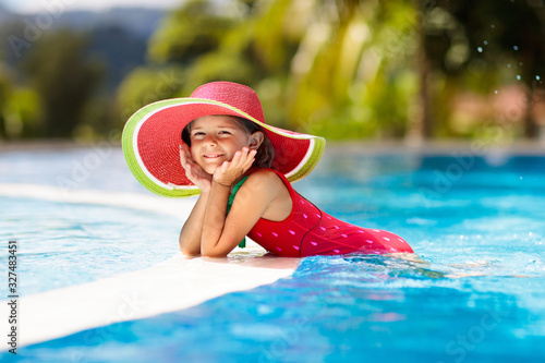 Child with hat in swimming pool. Tropical vacation © famveldman